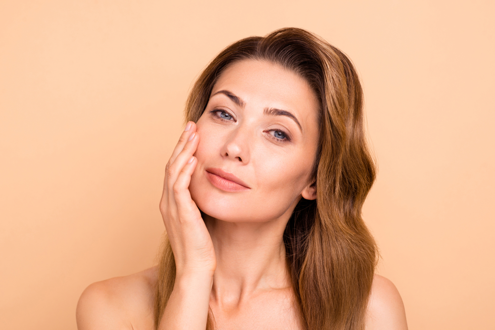 Woman touching her smooth skin after a Morpheus8 treatment.