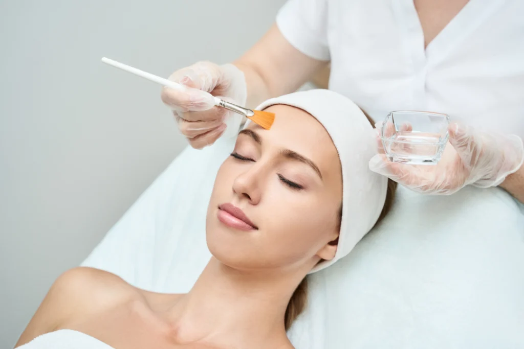 Professional applying a chemical peel to a client's face during a session.